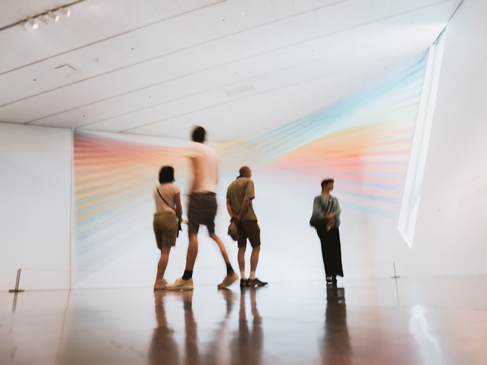 Visitors looking at artwork in a bright gallery